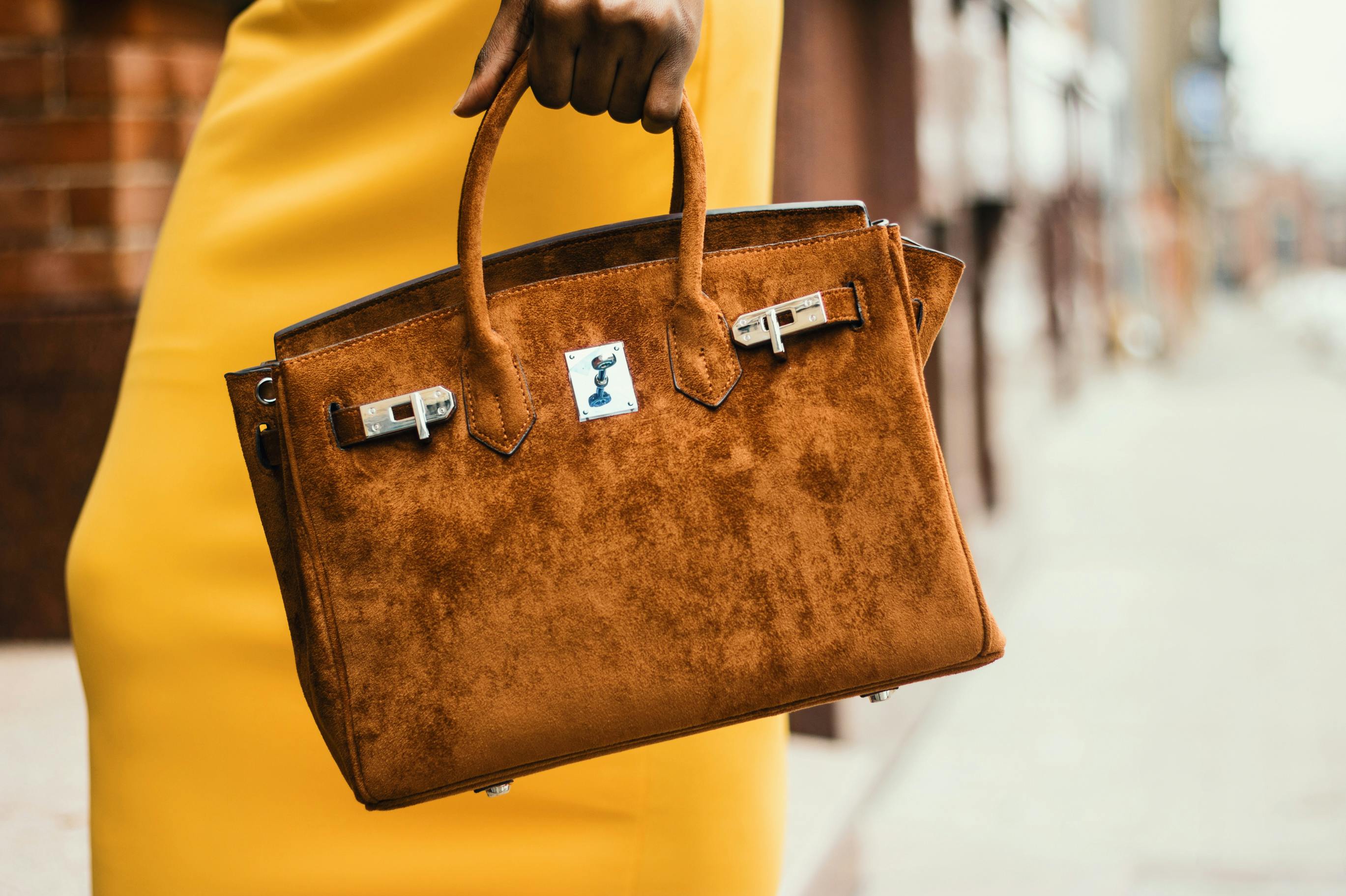 women is holding a yellow handbag